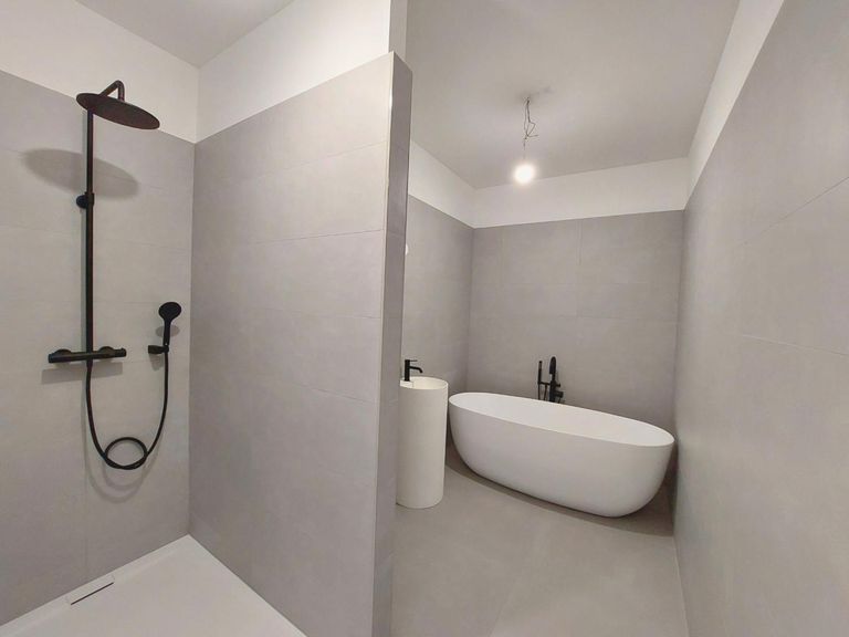 Badezimmer mit Badewanne und Dusche