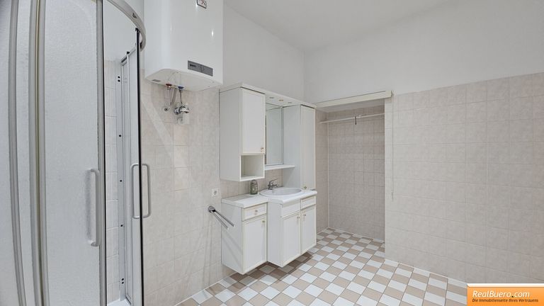 Badezimmer mit Dusche, Handwaschbecken, Waschmaschinenanschluss