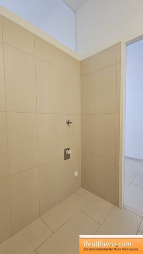 Badezimmer mit Dusche, Toilette, Handwaschbecken und Waschmaschinenanschluss