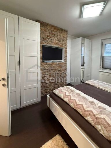 Schlafzimmer mit TV und Steindekor