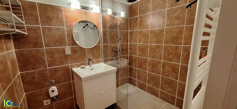 Schönes Badezimmer mit Dusche, Handtuchtrockner und Waschmaschinen Anschluss