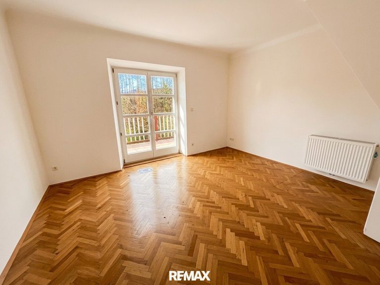Zimmer im Obergeschoss mit Zugang zum Balkon