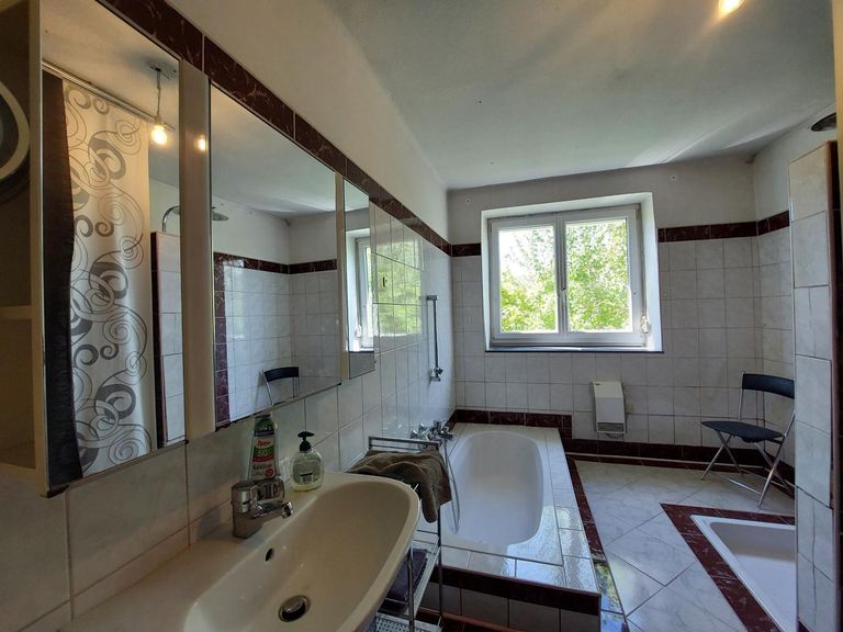 Badezimmer mit versenkter Badewanne und Dusche