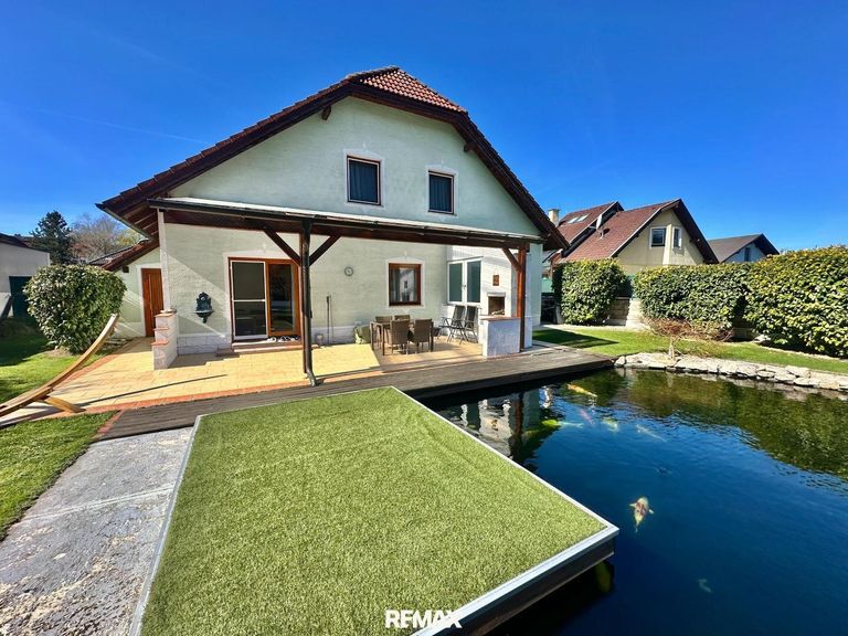 Teich mit Terrasse und Hausansicht