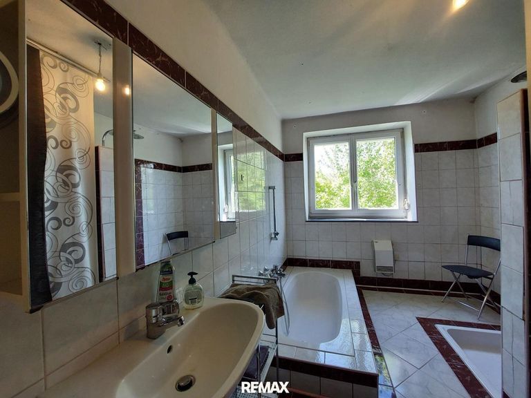 Badezimmer mit versenkter Badewanne und Dusche