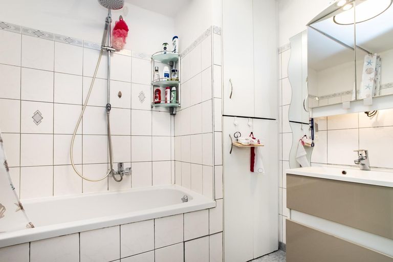 Badezimmer mit verbauter Waschmaschine und Trockne