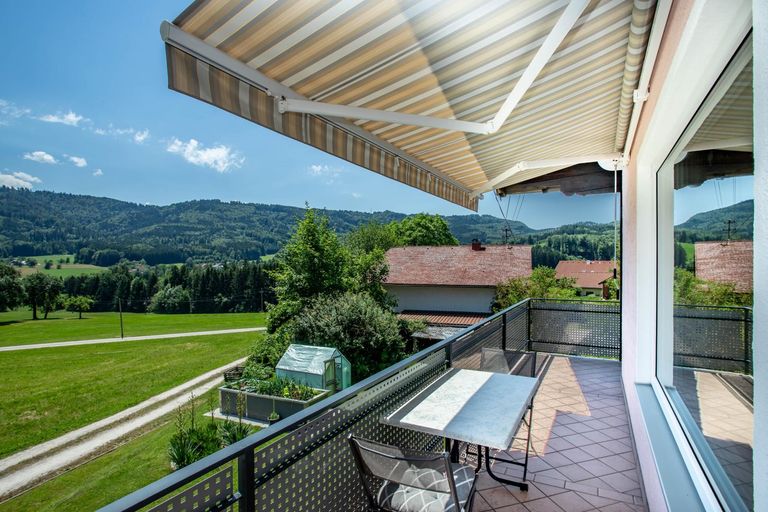 Gemütlicher sonniger Balkon mit Markise