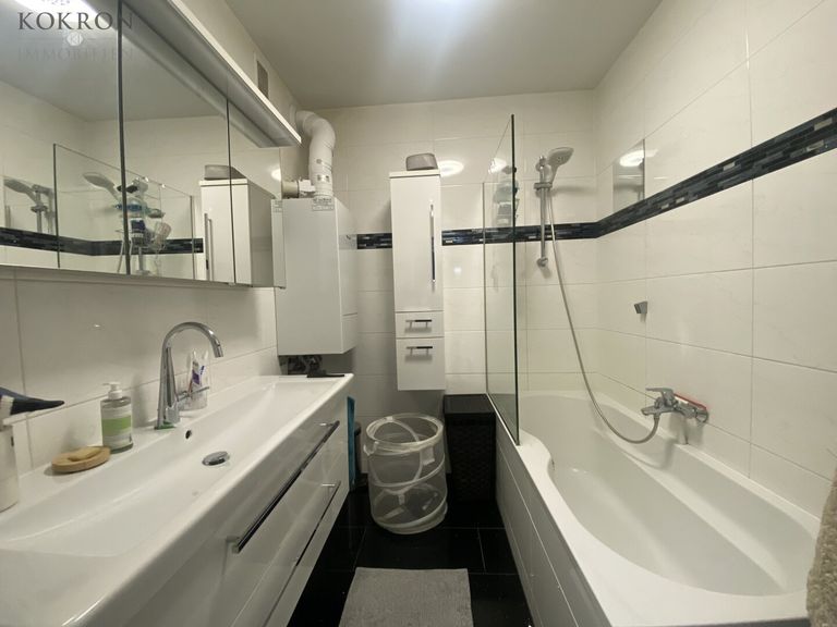 Zeitloses Bad mit Badewanne und großzügigem Waschtisch.