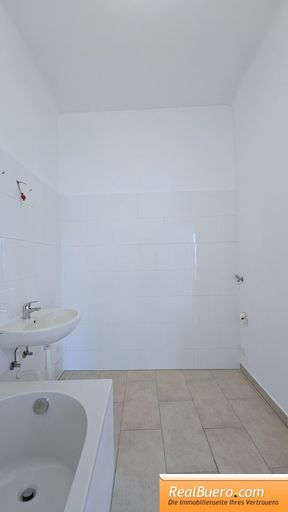 Badezimmer mit Wanne, Handwaschbecken und Waschmaschinenanschluss