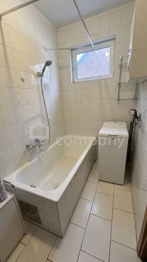 Badezimmer mit Wanne, Fenster und Waschmaschinenanschluss