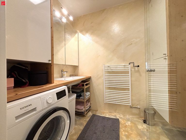 Badezimmer mit Tischlermöbeln und Handtuchtrockner