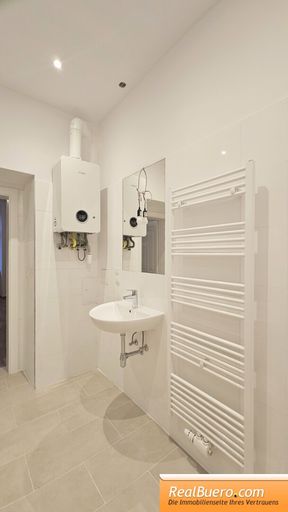 Badezimmer mit Dusche Handwaschbecken und Waschmaschinenanschluss