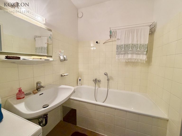 Badezimmer mit Wanne und Waschmaschine