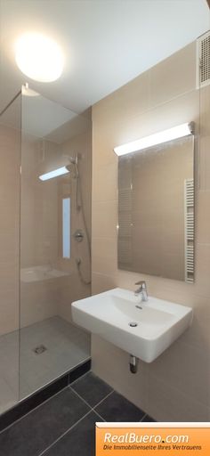 Badezimmer mit Dusche, Handwaschbecken und Sprossenheizkörper