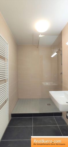 Badezimmer mit Dusche, Handwaschbecken und Sprossenheizkörper