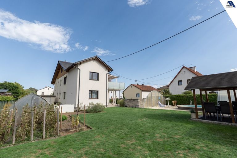 Hausansicht mit Garten und Glashaus