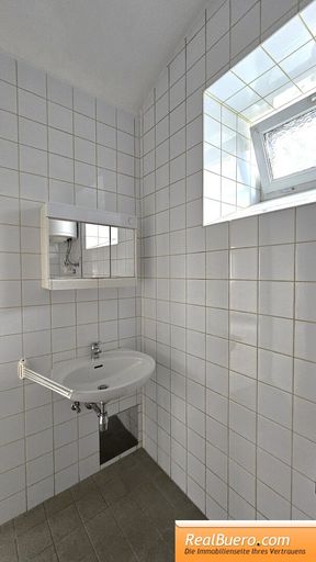 Badezimmer mit Dusche, Handwaschbecken und Toilette