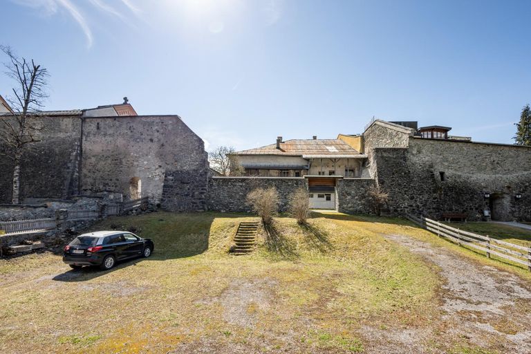 Grund mit Stadtmauer und Haus dahinter