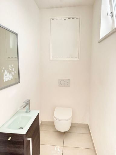 separates WC mit Waschbecken und Fenster