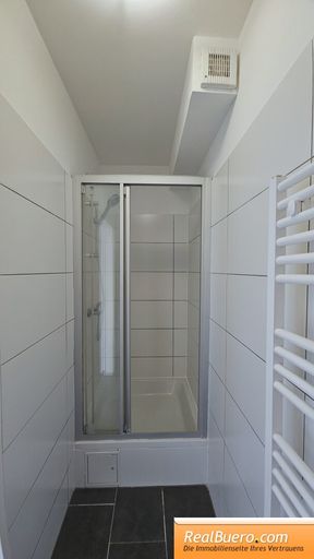 Badezimmer mit Dusche und Handwaschbecken