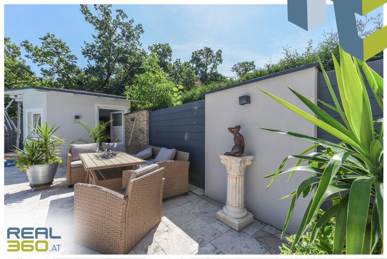 Blick auf die Terrasse und das Poolhaus