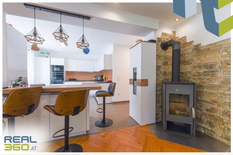 Küche mit Barbereich und Kamin im EG