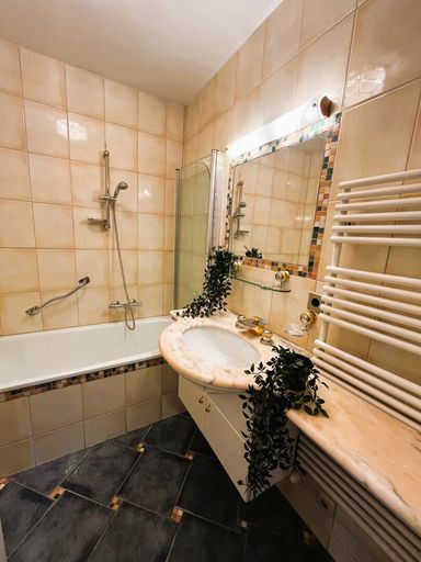 Badezimmer mit Marmorwaschbecken und Wasserfall-Wasserhahn