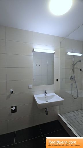 Badezimmer mit Dusche, Handwaschbecken, Waschmaschinenanschluss