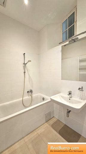 Badezimmer mit Wanne, Handwaschbecken, Handtuchtrockner, Waschmaschinenanschluss