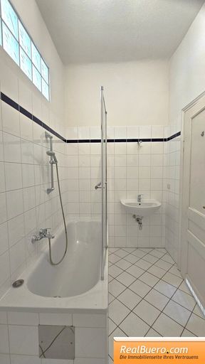 Badezimmer mit Wanne, Toilette, Handwaschbecken, Waschmaschinenanschluss,