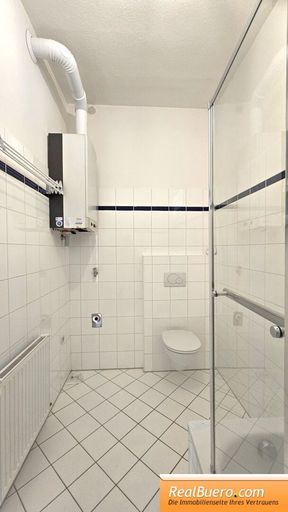 Badezimmer mit Wanne, Toilette, Handwaschbecken, Waschmaschinenanschluss,