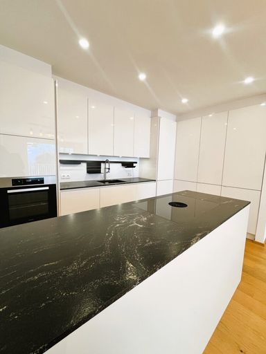 Elegante Miele-Küche mit Markengeräten und Natursteinplatte