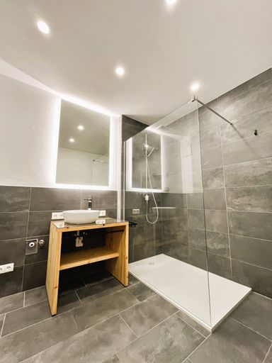 Modernes Bad mit Infinity-Dusche und Regenbrause