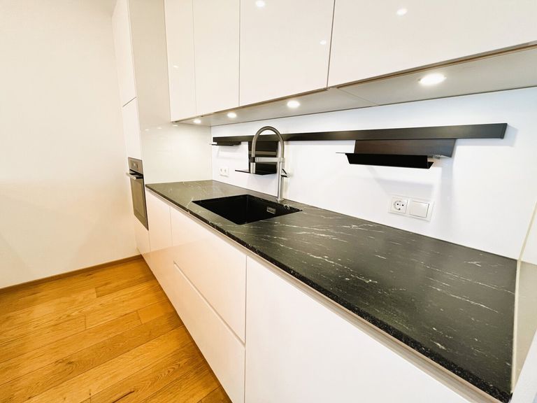 Elegante Miele-Küche mit Markengeräten und Natursteinplatte