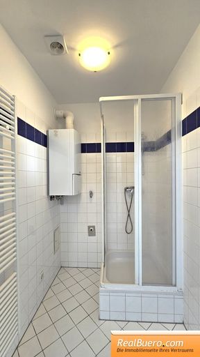 Badezimmer mit Dusche, Handwaschbecken, Waschmaschinenanschluss