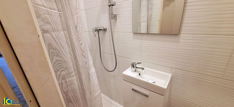 Badezimmer mit Dusche und Handwaschbecken