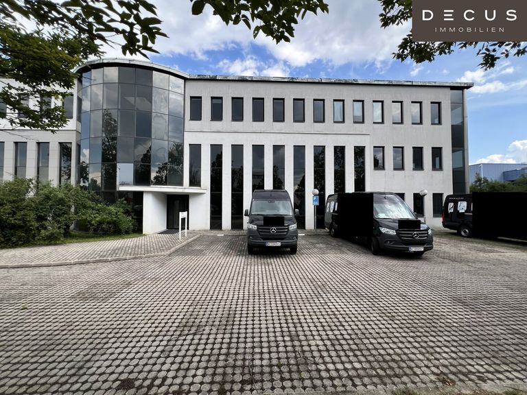Außenansicht Haupteingang inkl. Parkplätzen vor dem Gebäude