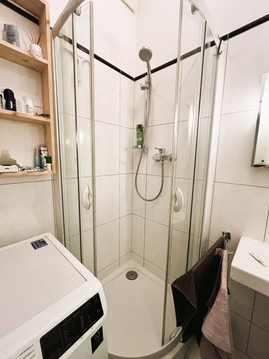 Badezimmer mit Dusche, WC, Waschbecken und Waschmaschinenanschluss