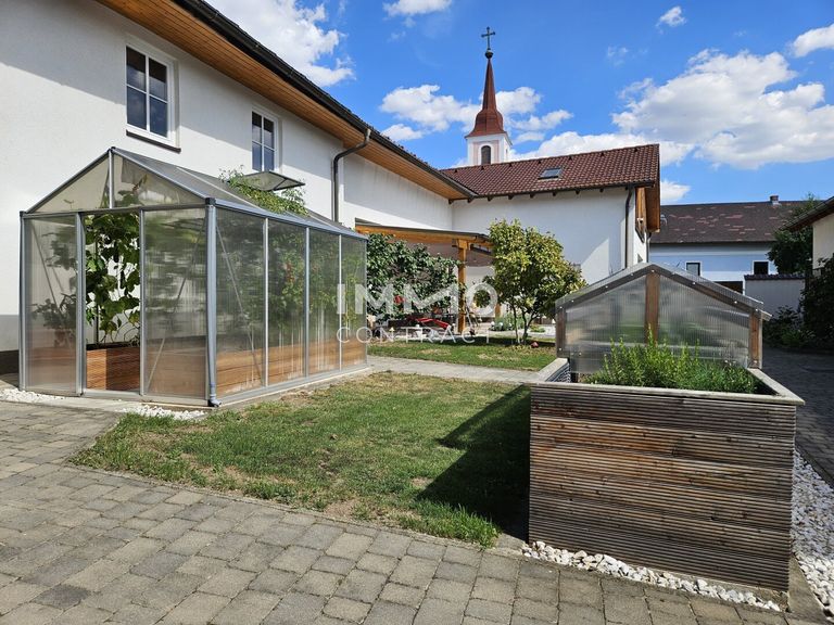 Innenhof mit Glashaus und Hochbeet