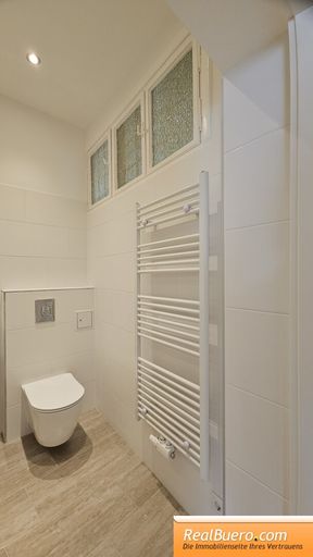 Badezimmer mit Dusche Handwaschbecken und Waschmaschinenanschluss